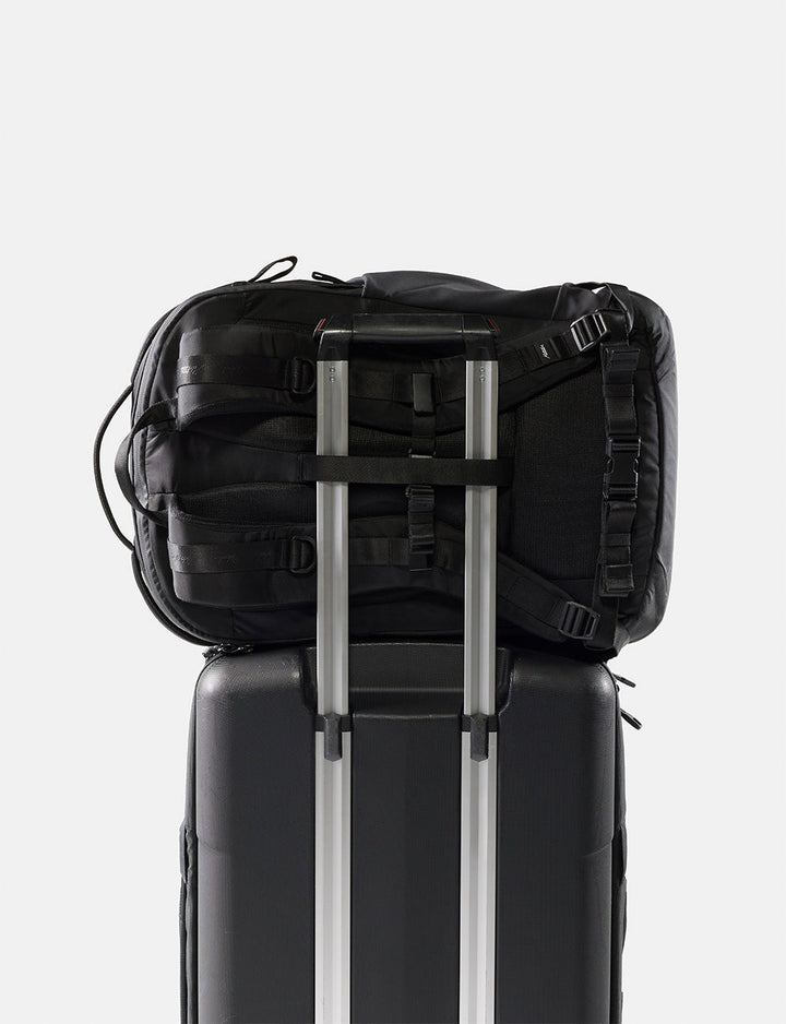 Matador 30L Carry-On Travel Pack in Black - black backpack on top of a black suitcase with a white background