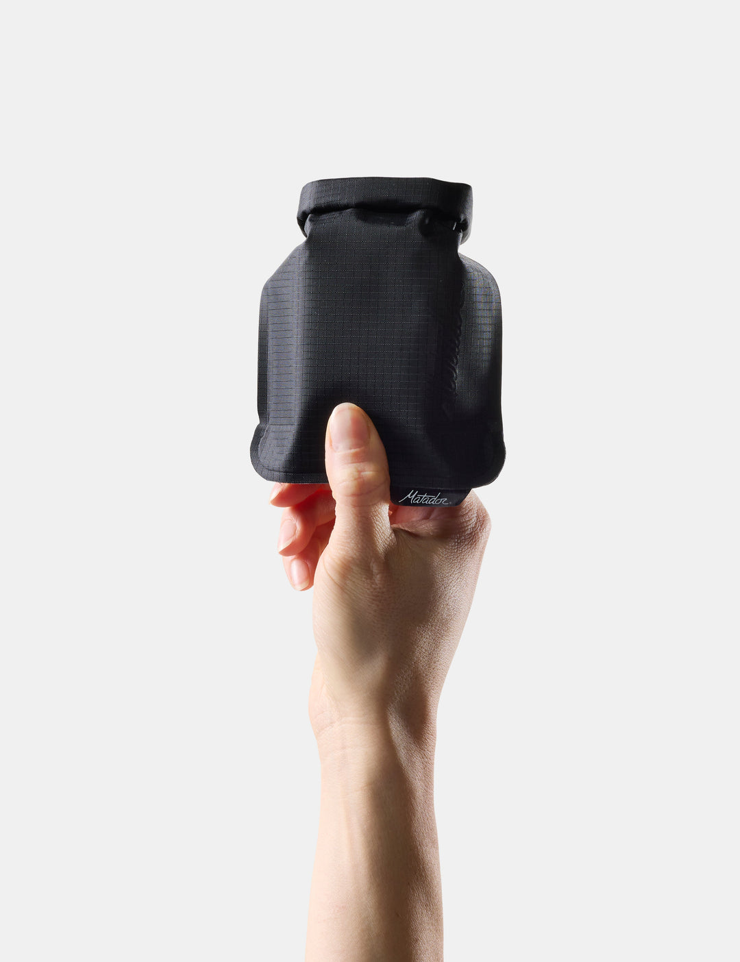 Matador FlatPak Travel Soap Bar Case (V2) in Black - hand holding Black soap bar case against a white background