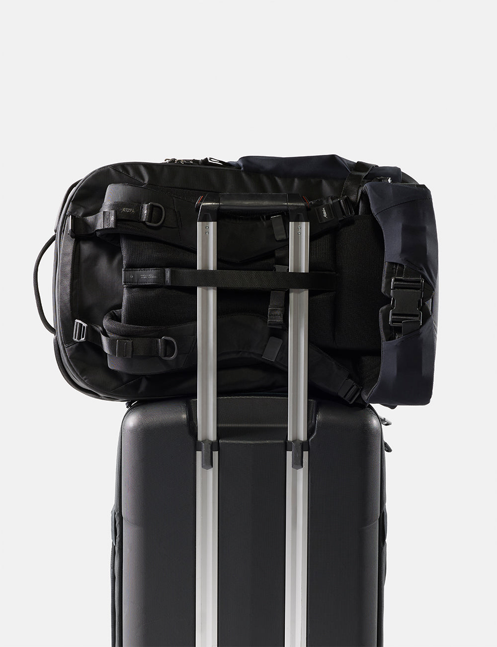 Matador 45L Global Travel Pack in Black - black backpack on top of a suitcase with a white background