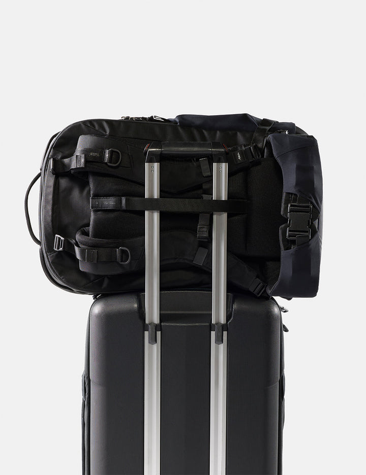 Matador 45L Global Travel Pack in Black - black backpack on top of a suitcase with a white background