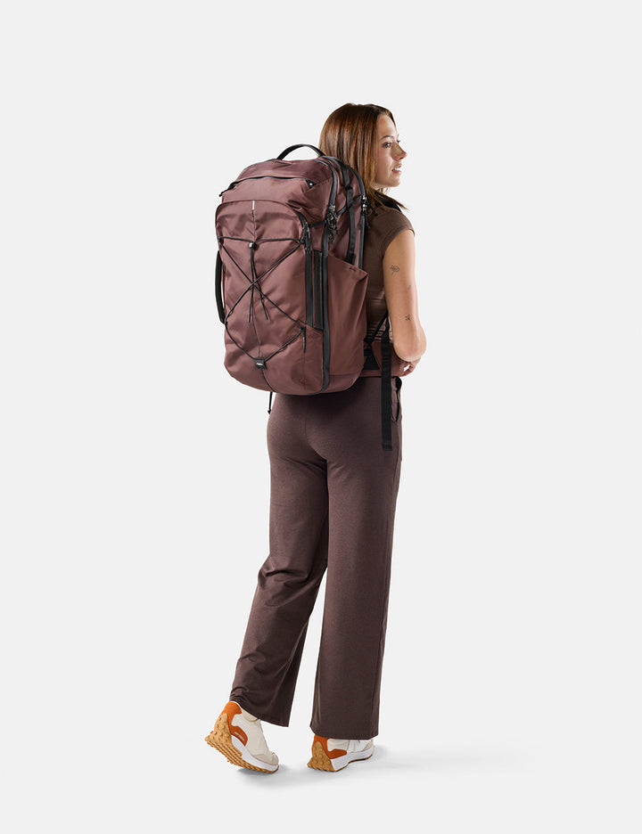 Matador 45L Global Travel Pack in Garnet - person wearing a garnet backpack on a white background
