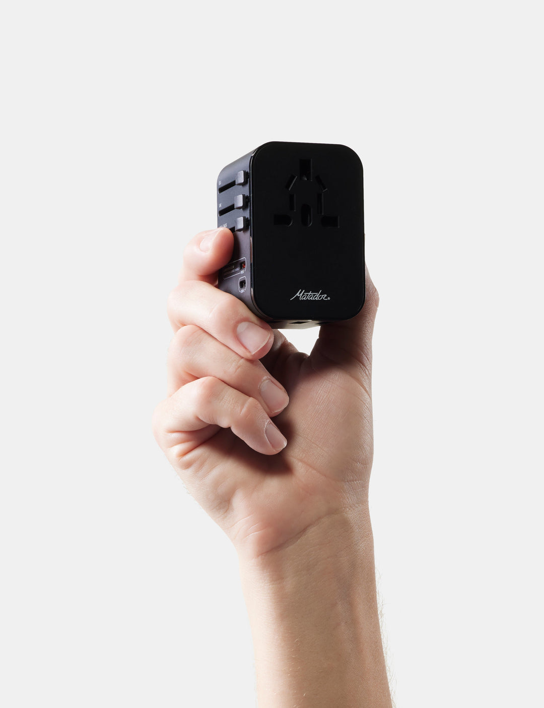 Matador Global Travel Adapter in Black - hand holding a black travel adapter with &