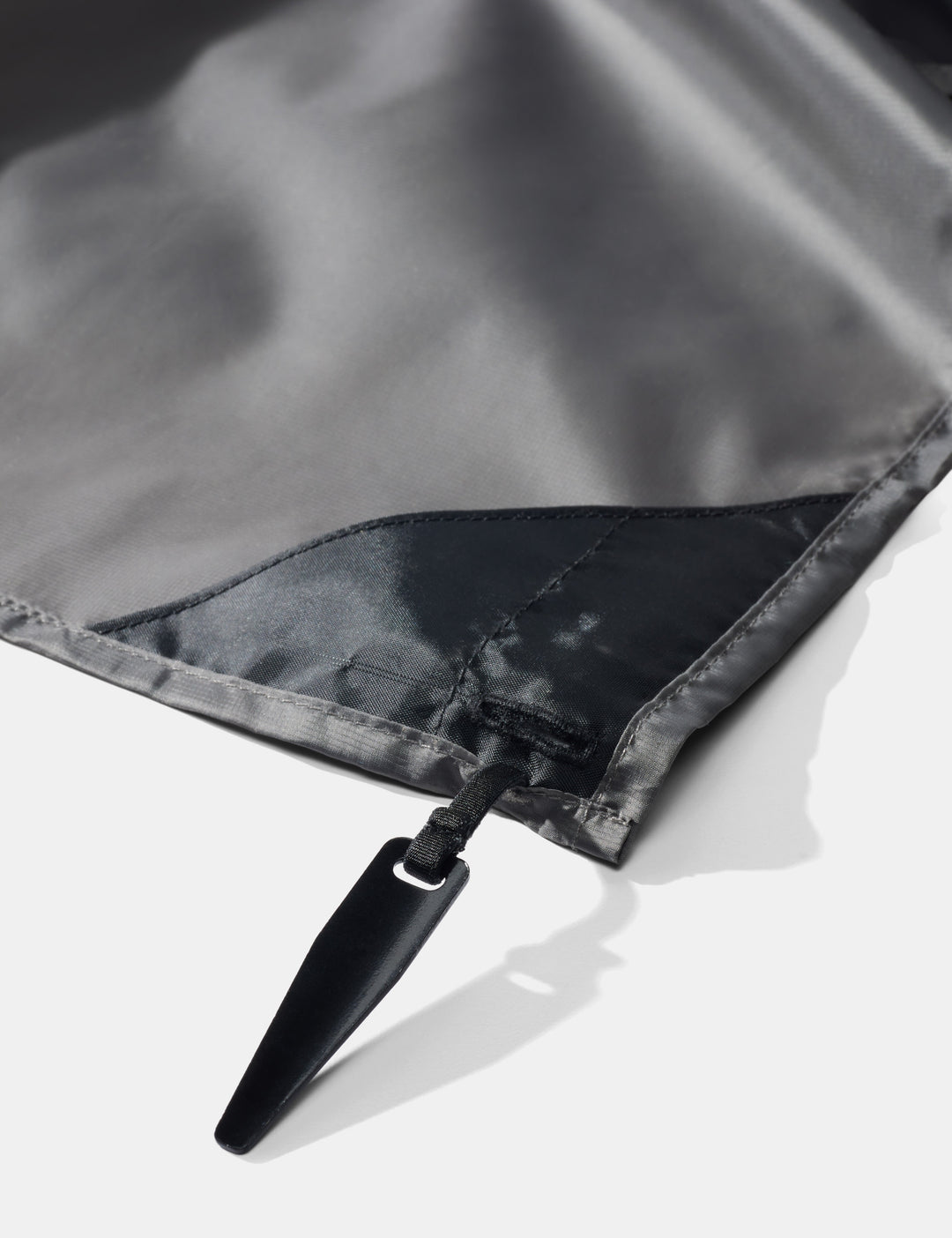 Matador Pocket Blanket™ 4.0 - 160 x 110cm in Ghost Grey - close-up of pocket blanket corner stake on a white background