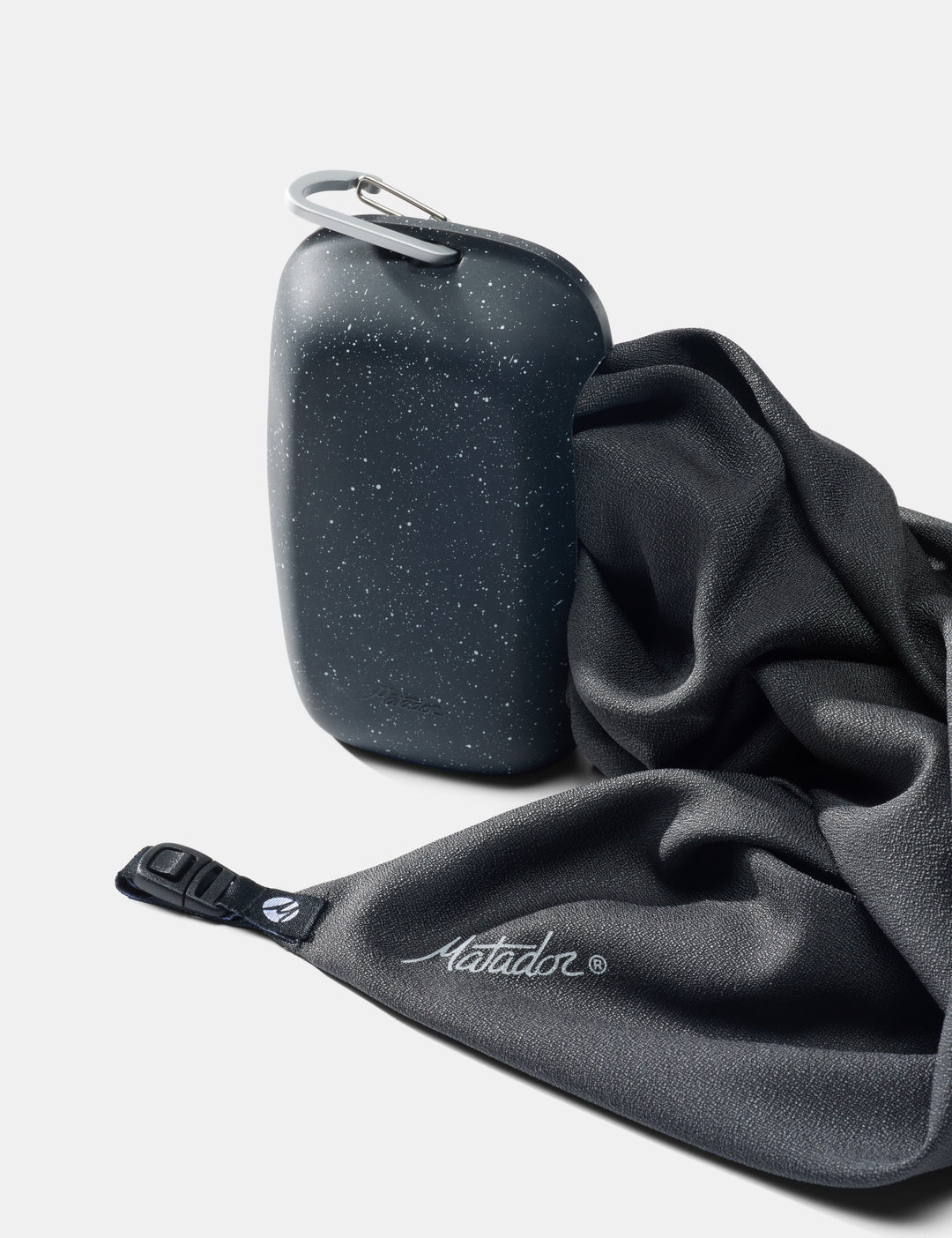 Matador NanoDry Towel - Large 132 x 60cm in Black Granite - nanodry towel being pulled out of silicone case on white background