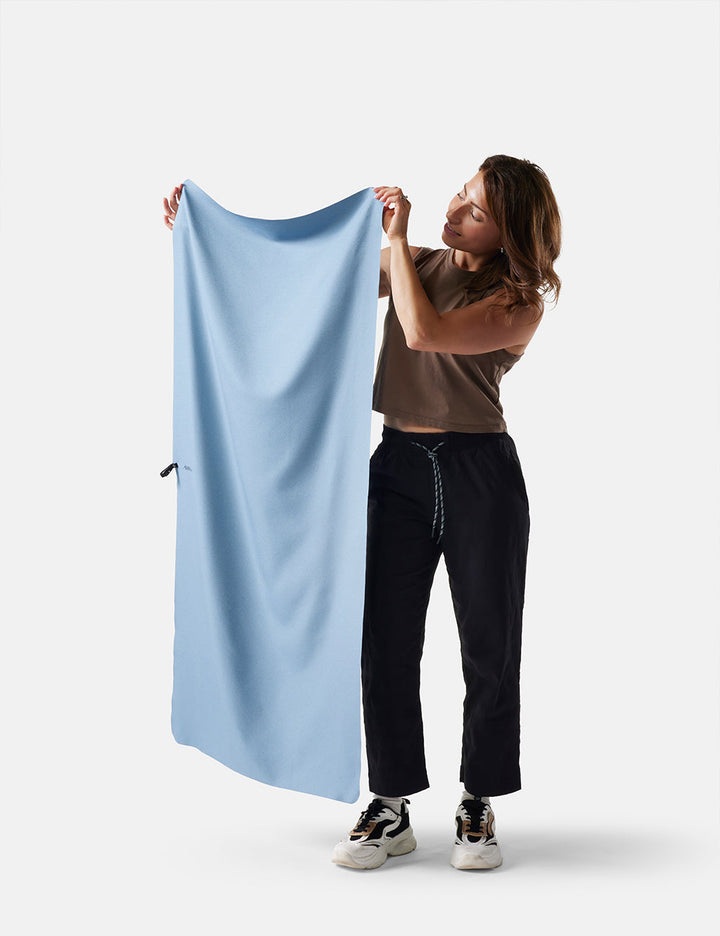 Matador NanoDry Towel - Large 132 x 60cm in Blue - person holding a slate towel against a white background
