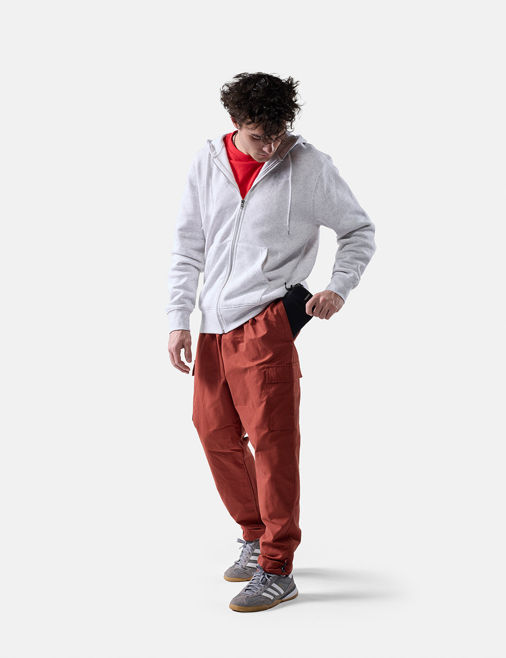 Matador Global Travel Stash in Black - man on white background placing travel wallet in his pant pocket
