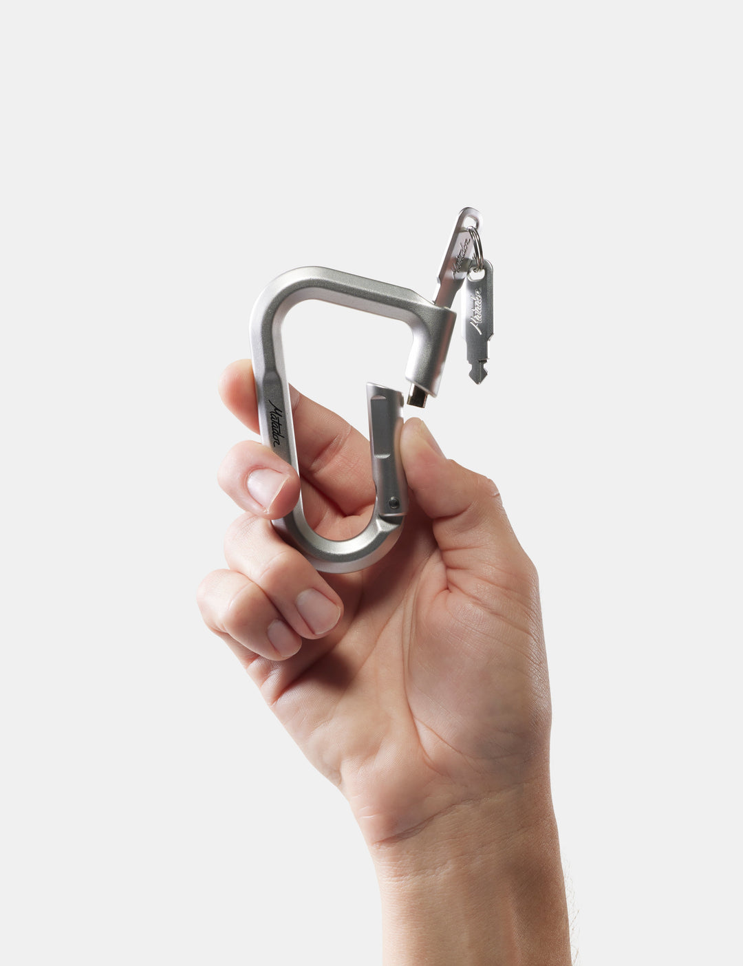 Matador BetaLock in Orchid - hand holding a metal carabiner against a white background