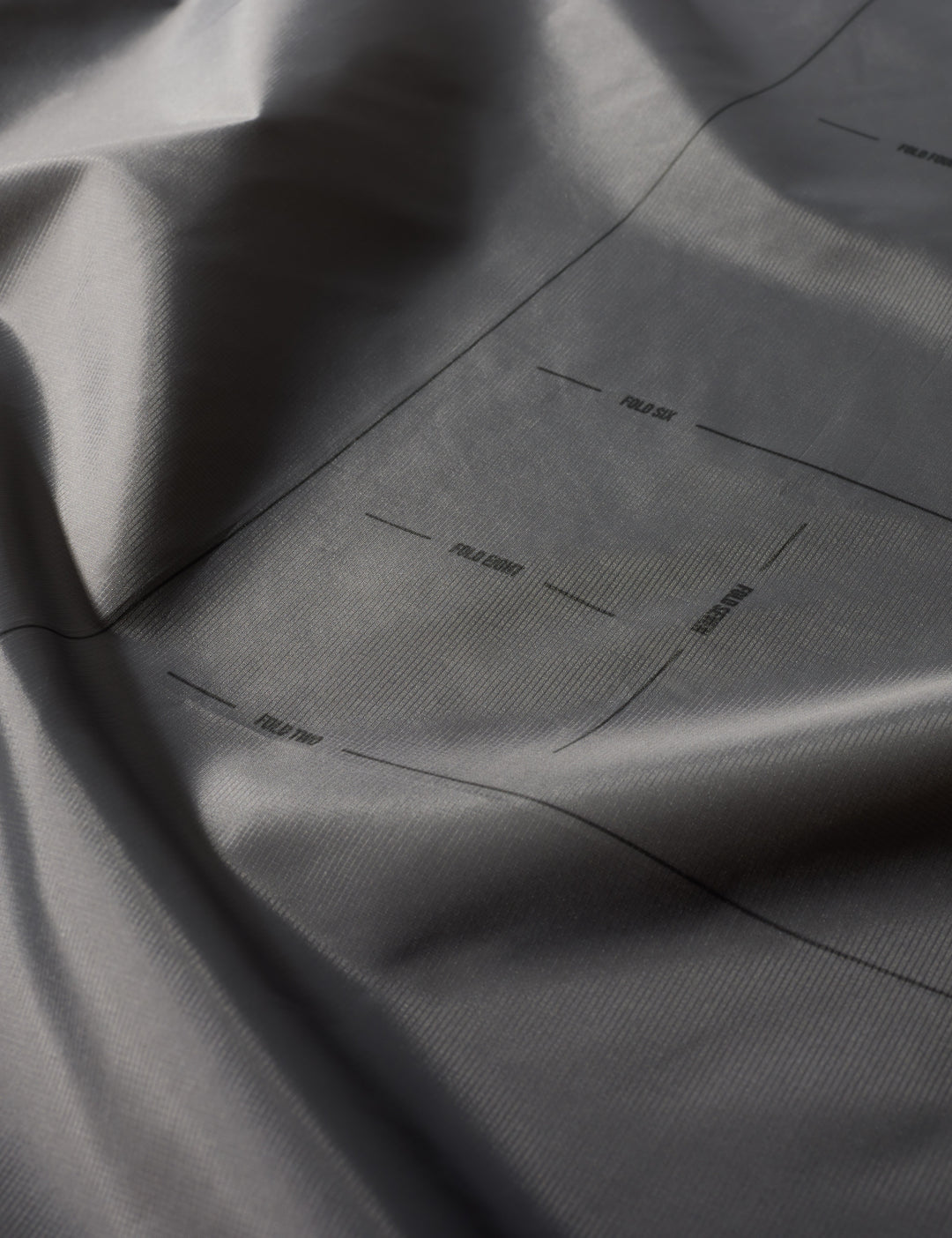 Matador Mini Pocket Blanket™ 4.0 - 110 x 70cm in Black - close-up of gray fabric with subtle texture and folds