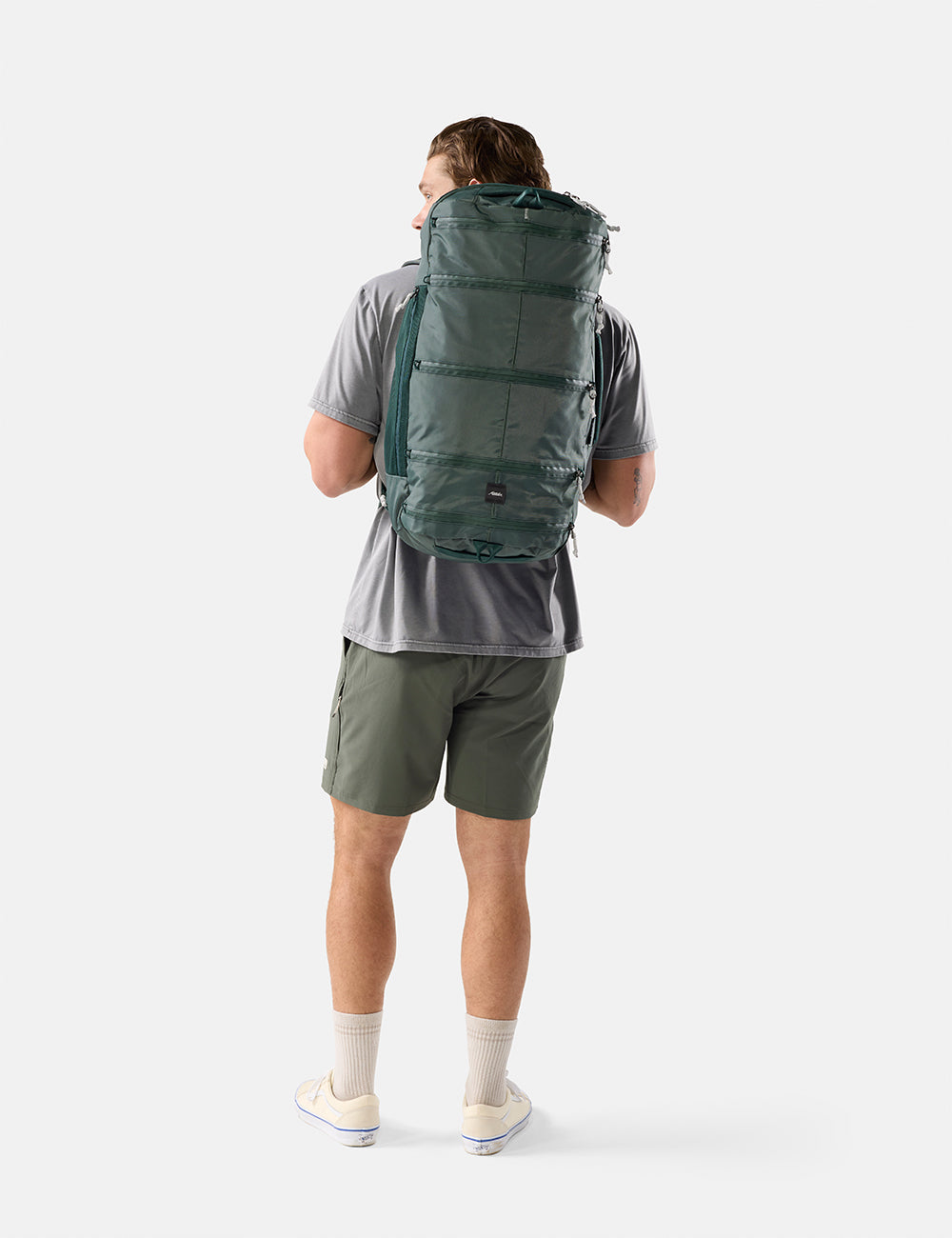 Matador 45L SEG Hybrid Travel Pack in Juniper - person wearing a green backpack on a white background