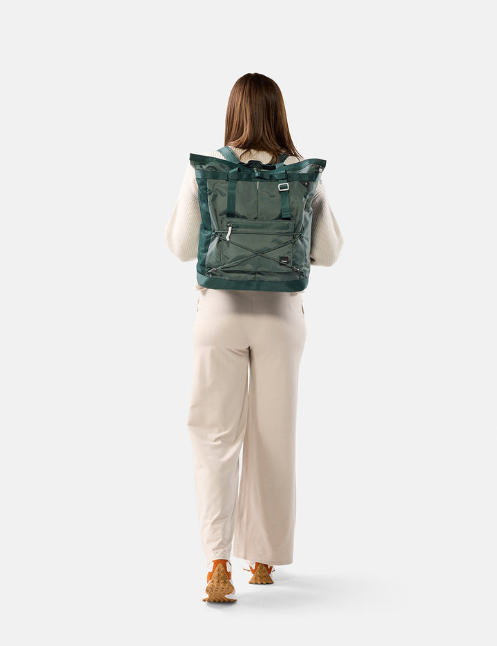 Matador 24L Tote Pack in Juniper - person wearing a green tote pack on a white background