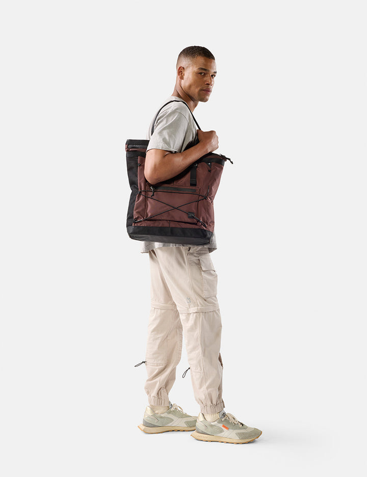 Matador 24L Tote Pack in Garnet - person carrying a garnet backpack on a white background