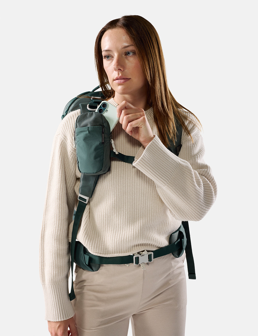 Matador Speed Stash (V2) in Juniper - woman wearing a green backpack and holding a phone against a white background