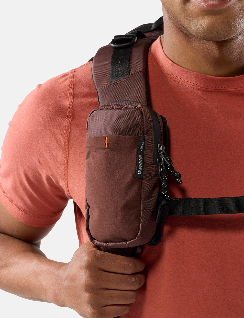 Matador Speed Stash (V2) in Garnet - person wearing a garnet crossbody bag on a plain background